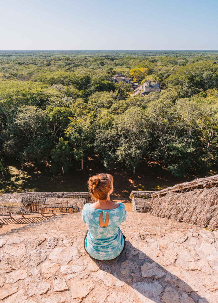 Bloggerin Melanie schaut auf die Maya Ruinen Ek Balam im Dschungel herab.