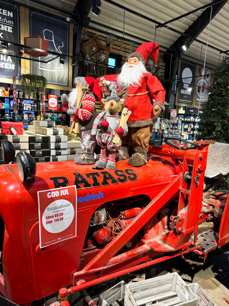 Weihnachtliche Figuren auf einem roten alten Traktor im Glaswerk Hadeland Glasverk.