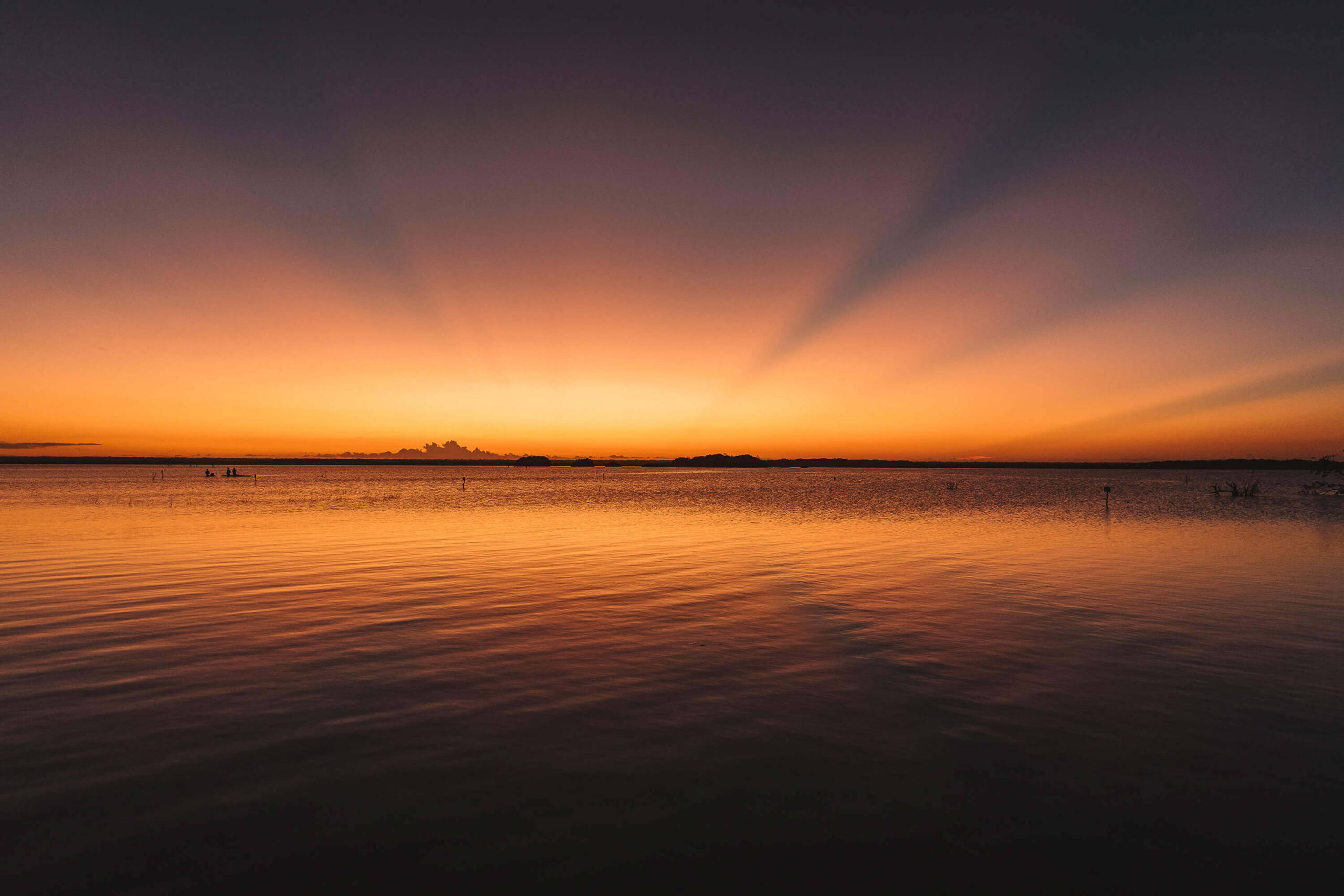 Der Sonnenaufgang über dem Wasser an der Laguna Bacalar auf Yucatan.