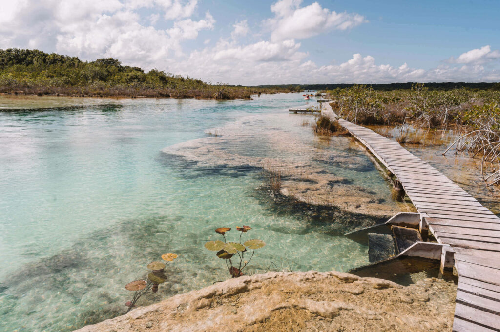 Ein Holzsteg auf Yucatan führt über das türkisfarbene Wasser des Strömungskanals Los Rapidos.