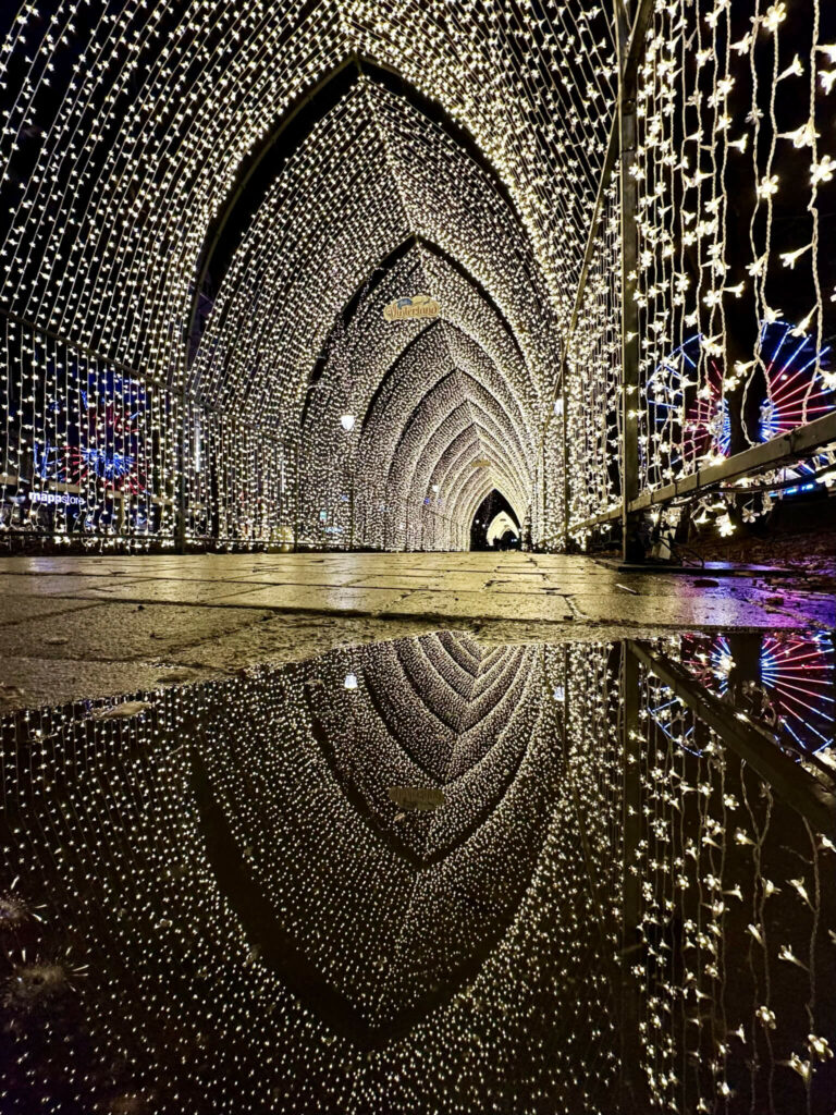 Der Lichtertunnel aus vielen weiß leuchtenden Lichterkettenauf dem Weihnachtsmarkt in Oslo bei Nacht.
