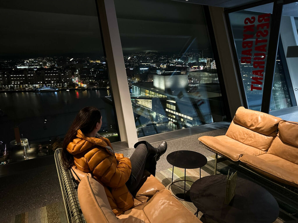 Bloggerin Biggi von Phototravelleres sitzt auf einem Sessel im Munch Museum mit Blick über Oslo.
