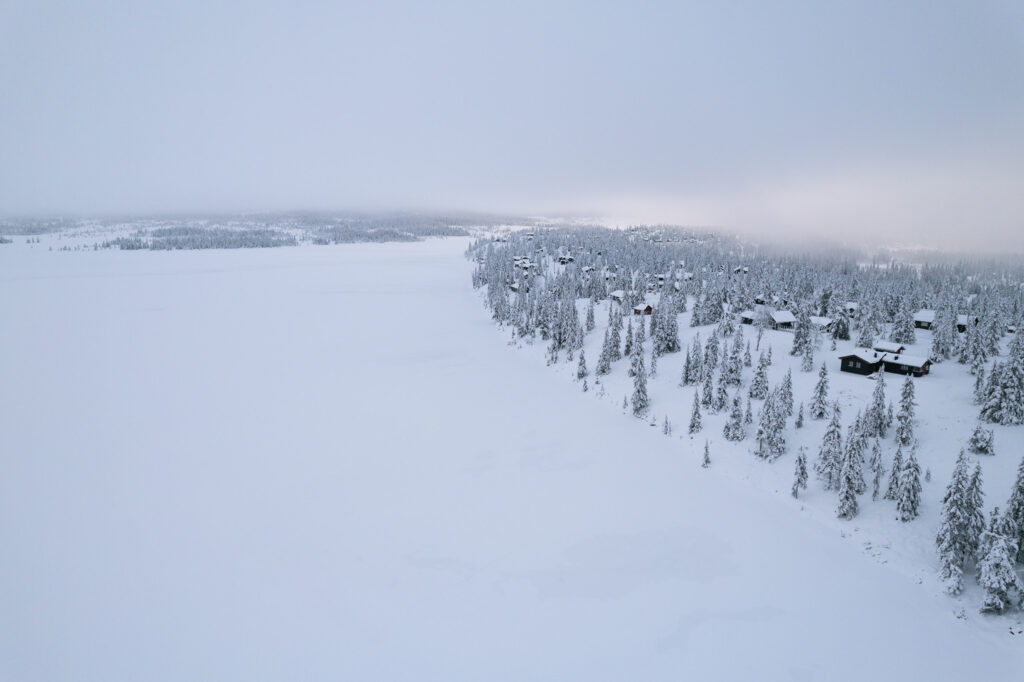 Ein zugefrorener und verschneiter See in der Winterlandschaft in Sjusjøen