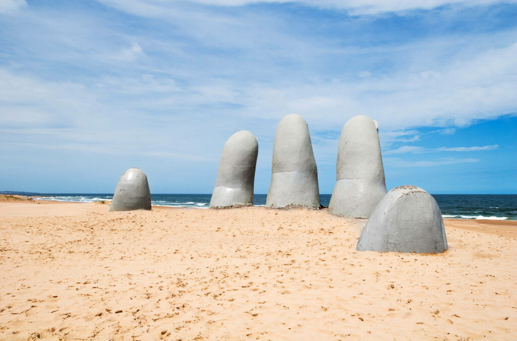 Die Steinhand La Mano ragt mit ihren Fingern aus dem Strand Punta el Elste in Uruguay heraus.