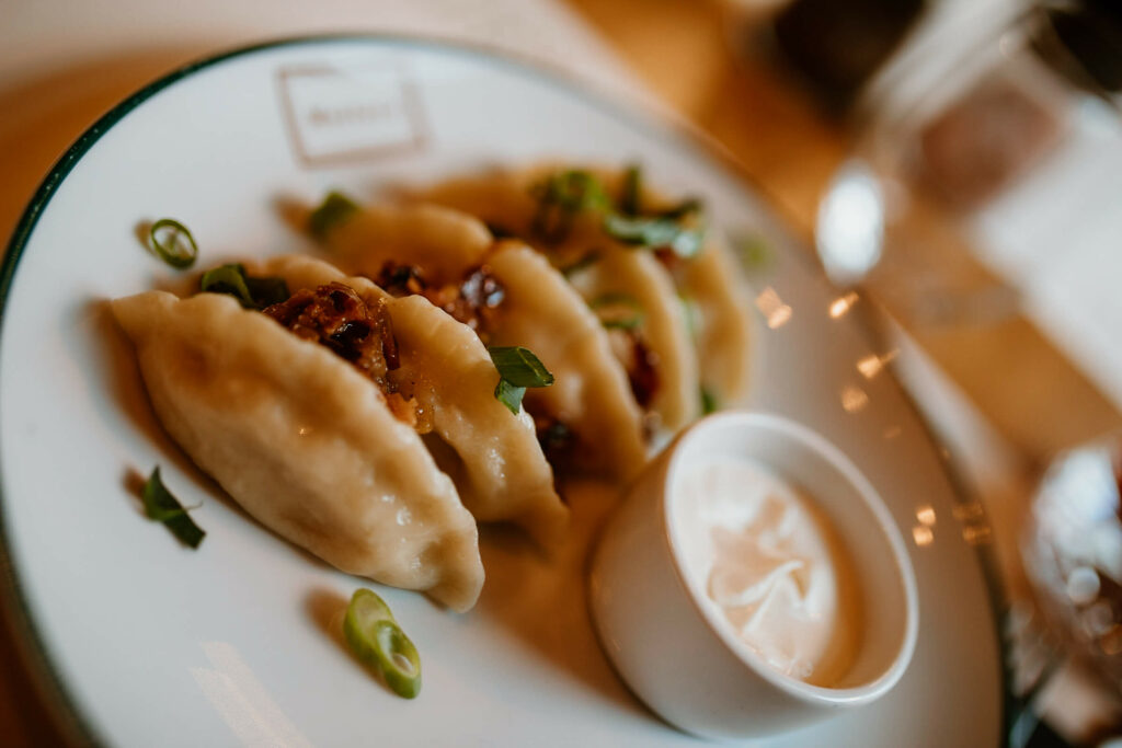 Das polnische Gericht Piroggen schmückt mit Sauerrahm einen Teller in einem Danziger Restaurant.