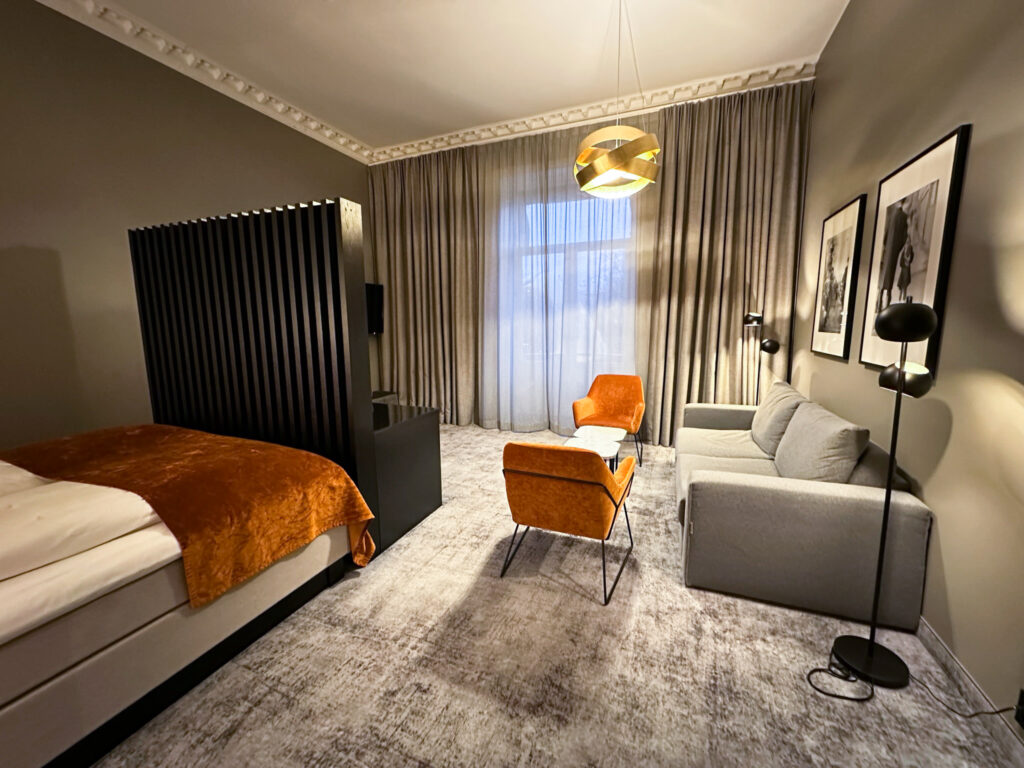 Ein Zimmer im Karl Johan Hotel in Oslo mit grauen und orangenen Möbeln.