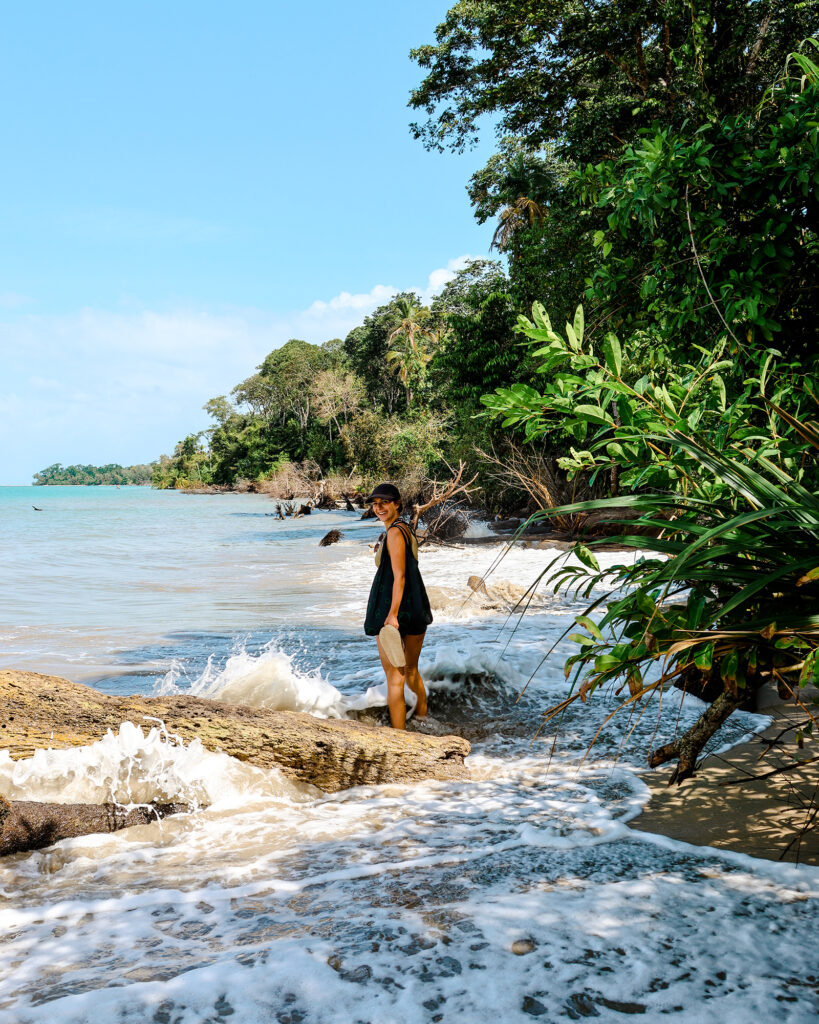 Bloggerin Nina steht am Strand des Cahuita Nationalparks in seichten Meer.