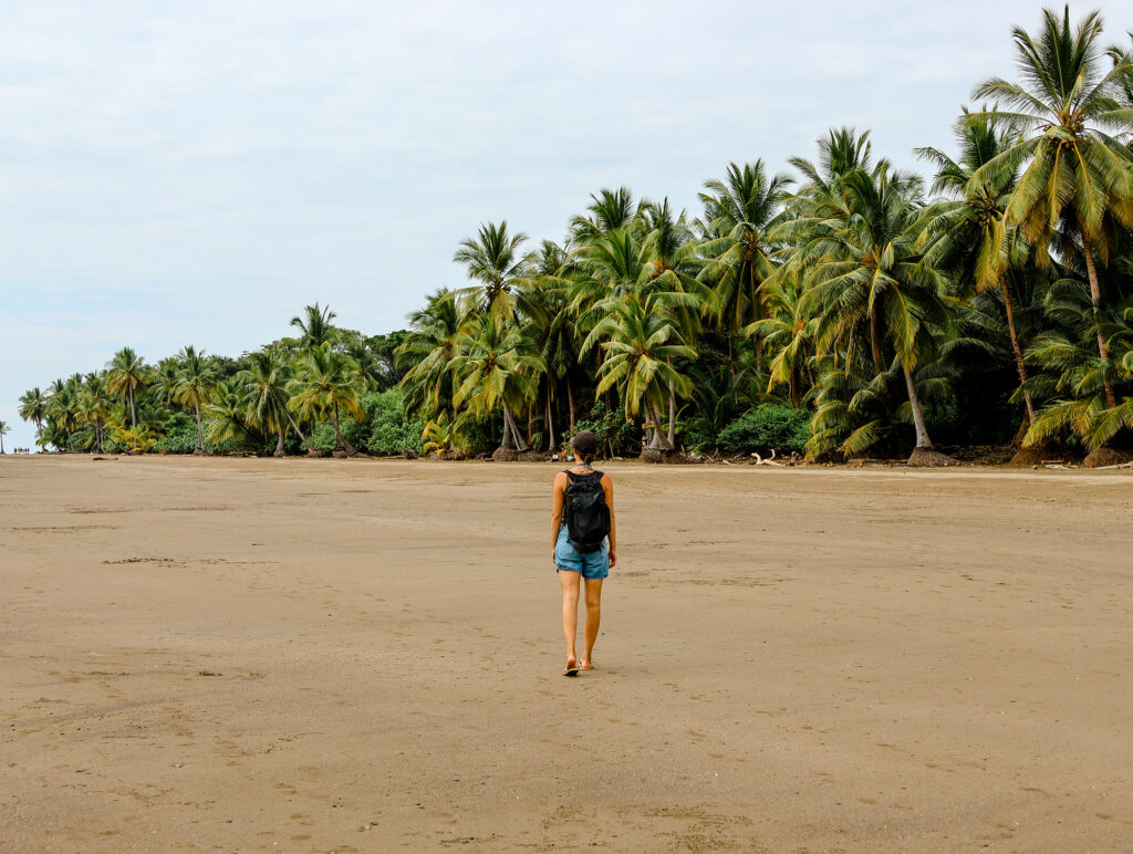 Bloggerin Nina öäuft auf die Kokosnusspalmen am Walflossenstrand in Costa Rica zu.
