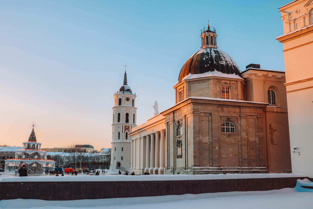 Vor der Kathedrale St. Stanislaus in Vilnius steht auf dem Platz ein beleuchteter Weihnachtsbaum.
