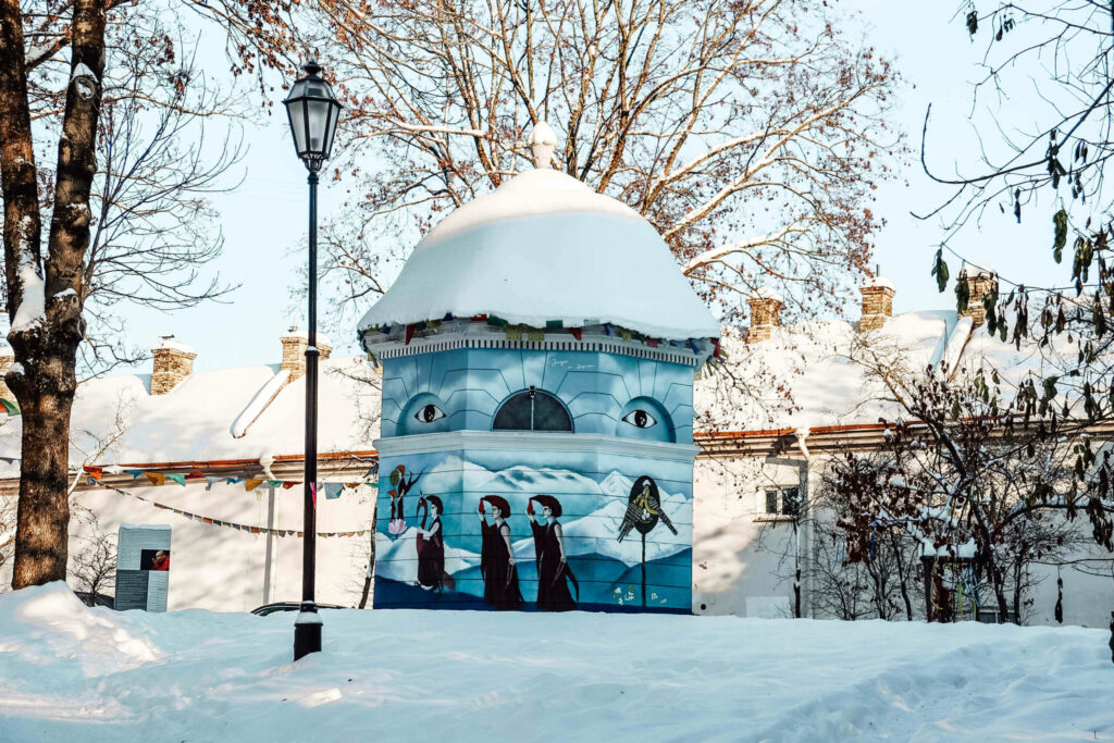 Ein rundes Gebäude mit Streetart bemalt im Viertel Uzupis in Vilnius.