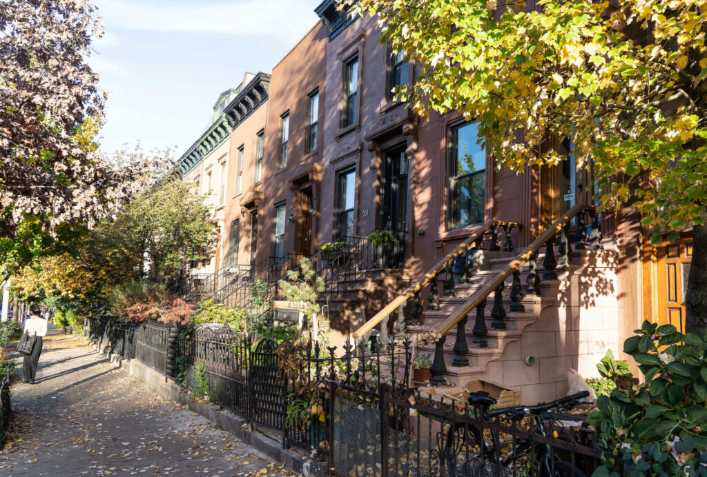 The Brownstone Houses, a symbol of Brooklyn, are row houses in different shades of brown with small gardens and stairs leading to the front doors.