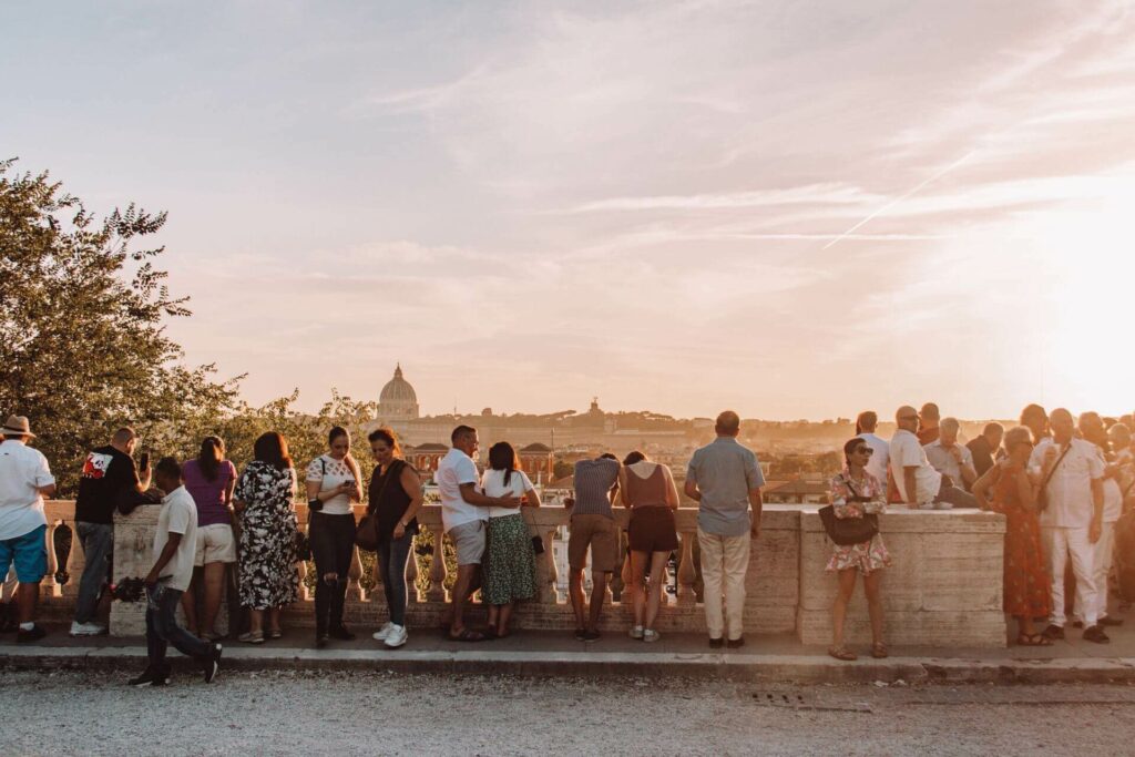 Viele Menschen genießen den Sonnenuntergang am Pincio-Hügel in Rom mit Blick auf die Stadt.