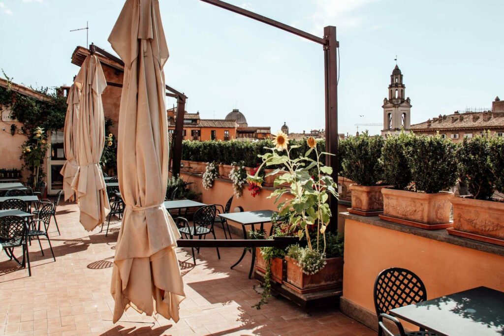 Die Terrasse des Hotel Hosianum Palace in Rom bestückt mit Stühlen und Schirmen.
