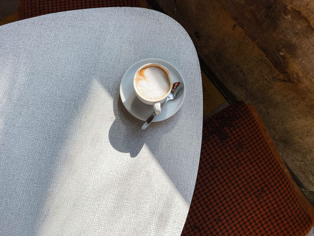 Ein Kaffee auf einem Tisch im Cafe Kosmos in München.