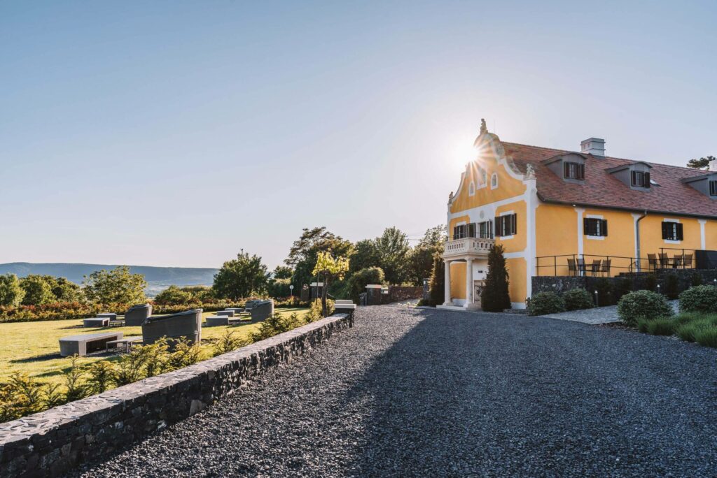 Ein Kiesweg führt zu dem gelben Haus des Weinguts in Balaton.