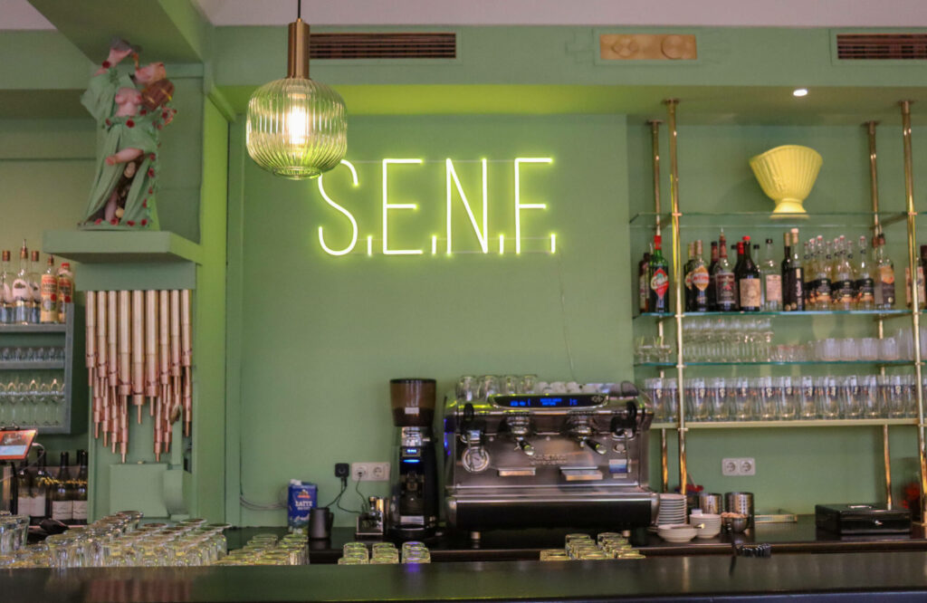 Im Münchner Café Fesch leuchtet in Neongrün der Schriftzug S.E.N.F.