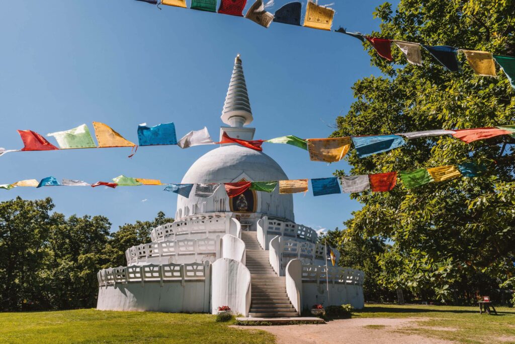 Ein weißes Gebäude, welches an eine Kirche erinnert mit bunten Flaggen im Vodergrund in Zalaszántó in Ungarn.