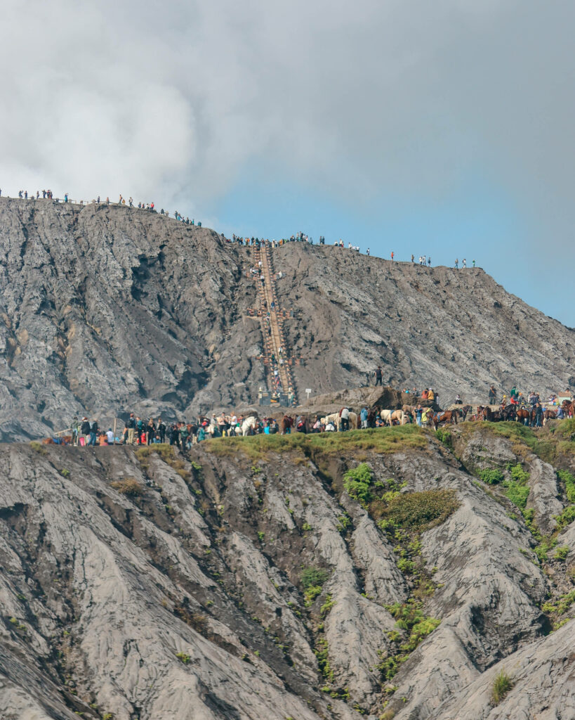 Menschenmassen wandern an den Kraterrand des Bromo Vulkans in Java.