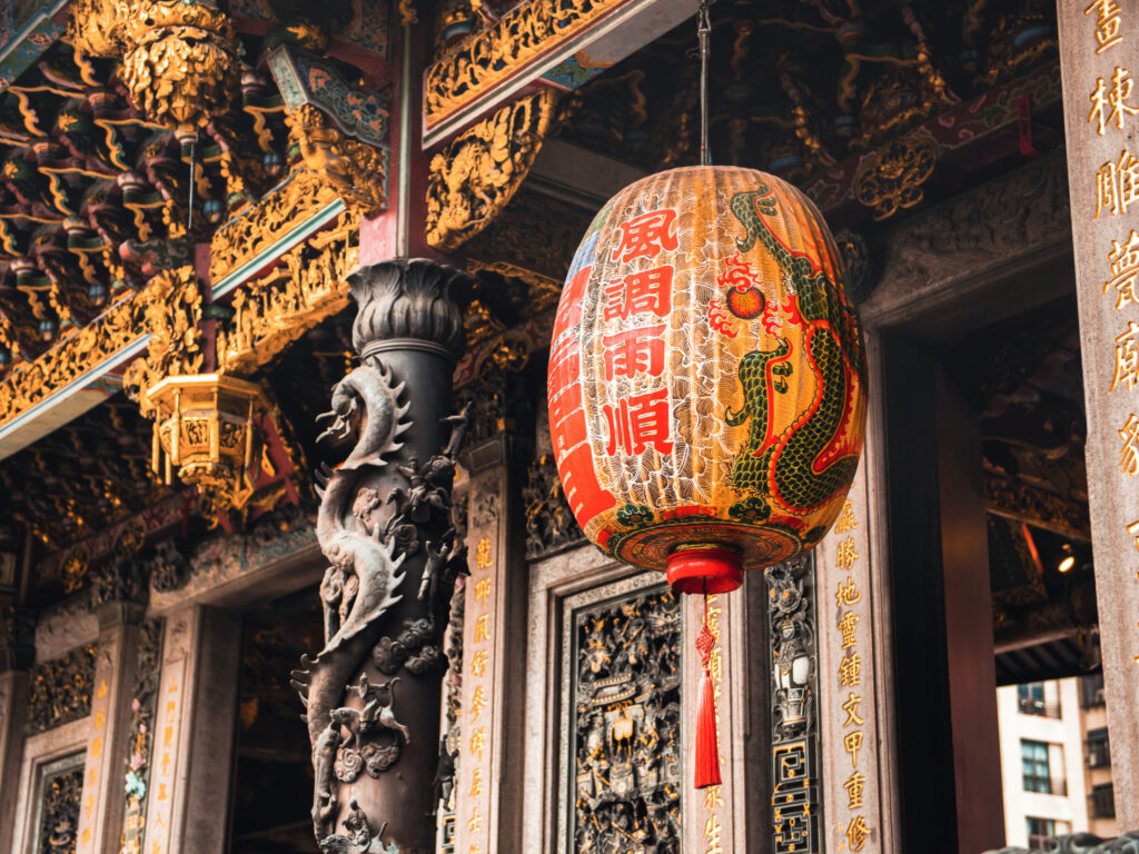 Prunkvolle Schnitzereien und ein Lampion im Longshan-Tempel in Taipeh.