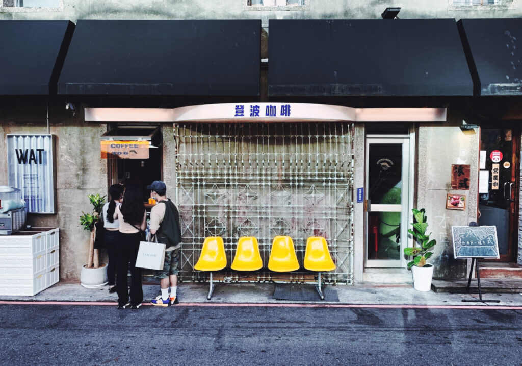 Das kleine Dumbo Café in taipeh mit gelben Stüheln vor dem Laden.
