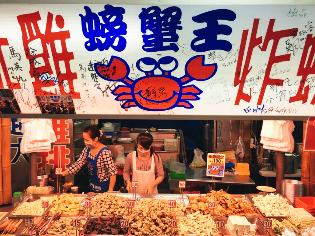 Zwei Frauen stehen hinter einem Essensstand auf dem Hualien Nachtmarkt in Taiwan.