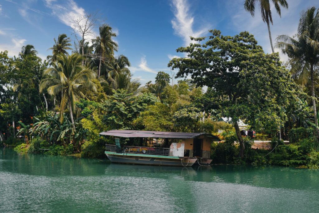 Ein kleines Holzboot steht am Ufer des Flusses Loboc River auf Bohol.