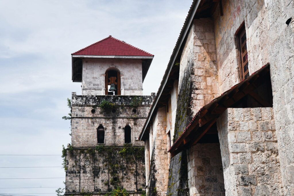 Der Turm der Baclayon-Kirche auf Bohol mit Glocke und rotem Dach ist eine wichtige Sehenswürdigkeit auf der philippinischen Insel.