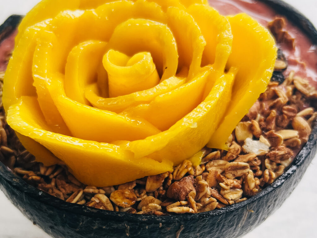 Eine leckere Bowl kunstvoll verziert mit einer Mango-Rose.