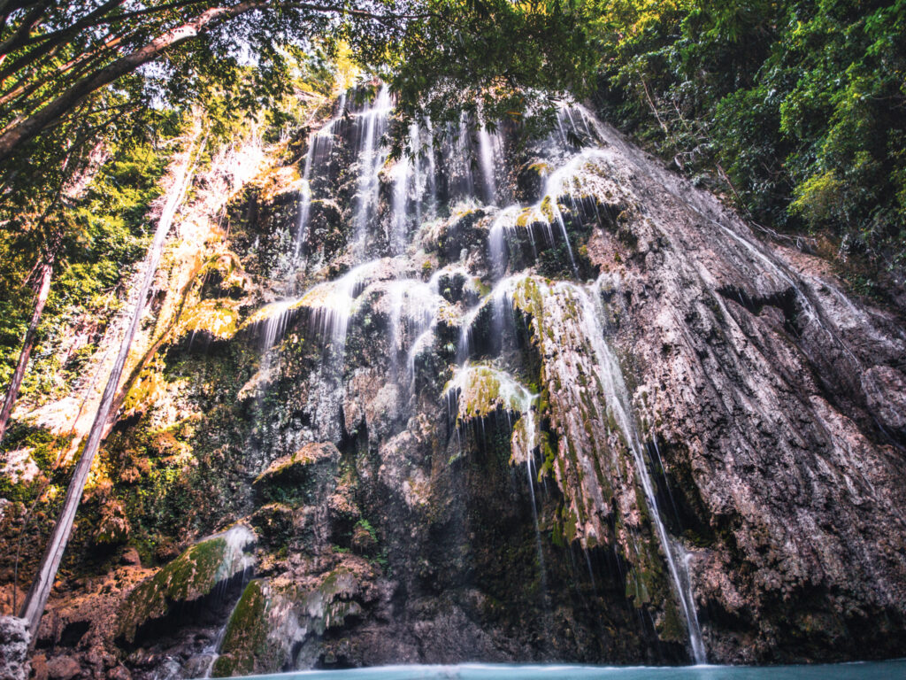 Das Wasser des Wasserfalls fließt über diverse Felsvorsprünge die Klippe hinunter.