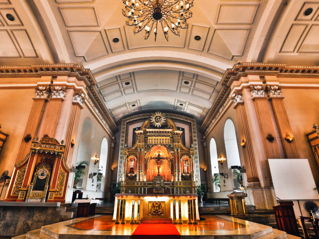 Ein großer Altar steht angestrahlt von warmem Licht in der Basilika.