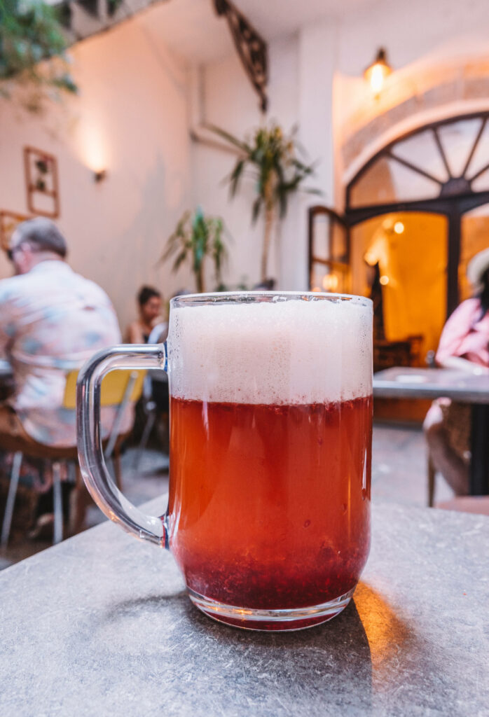 Ein Glas Bier mit Himbeer-Püree auf einem Tisch im ROESEL Bistro in Prag.
